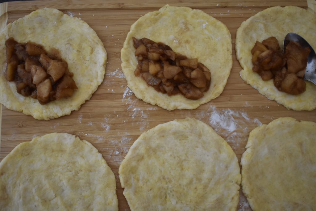 Grain free apple hand pies being made on a cutting board.