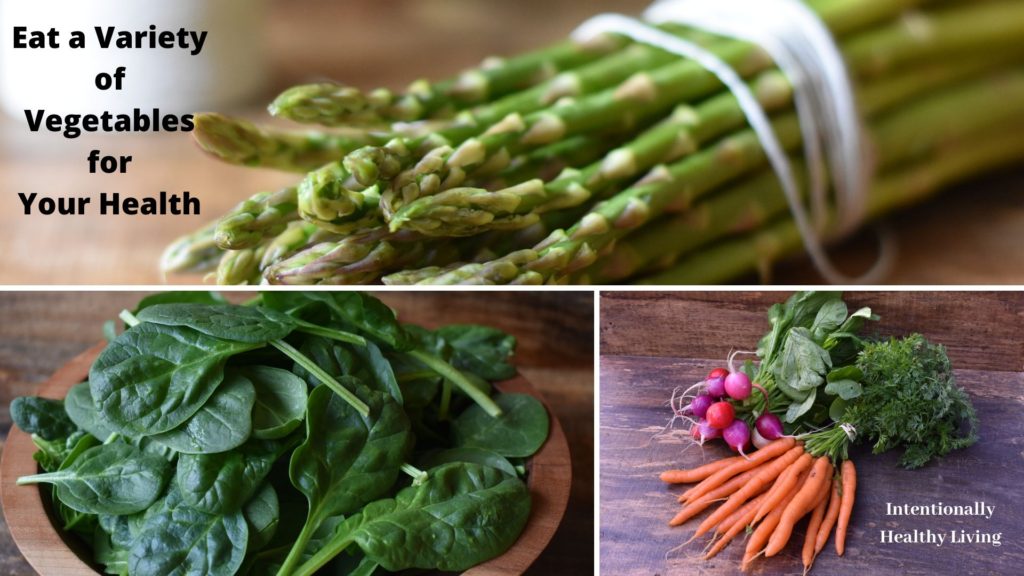 Eat the Rainbow in Vegetables.  Asparagus, spinach, radishes and carrots on a table.