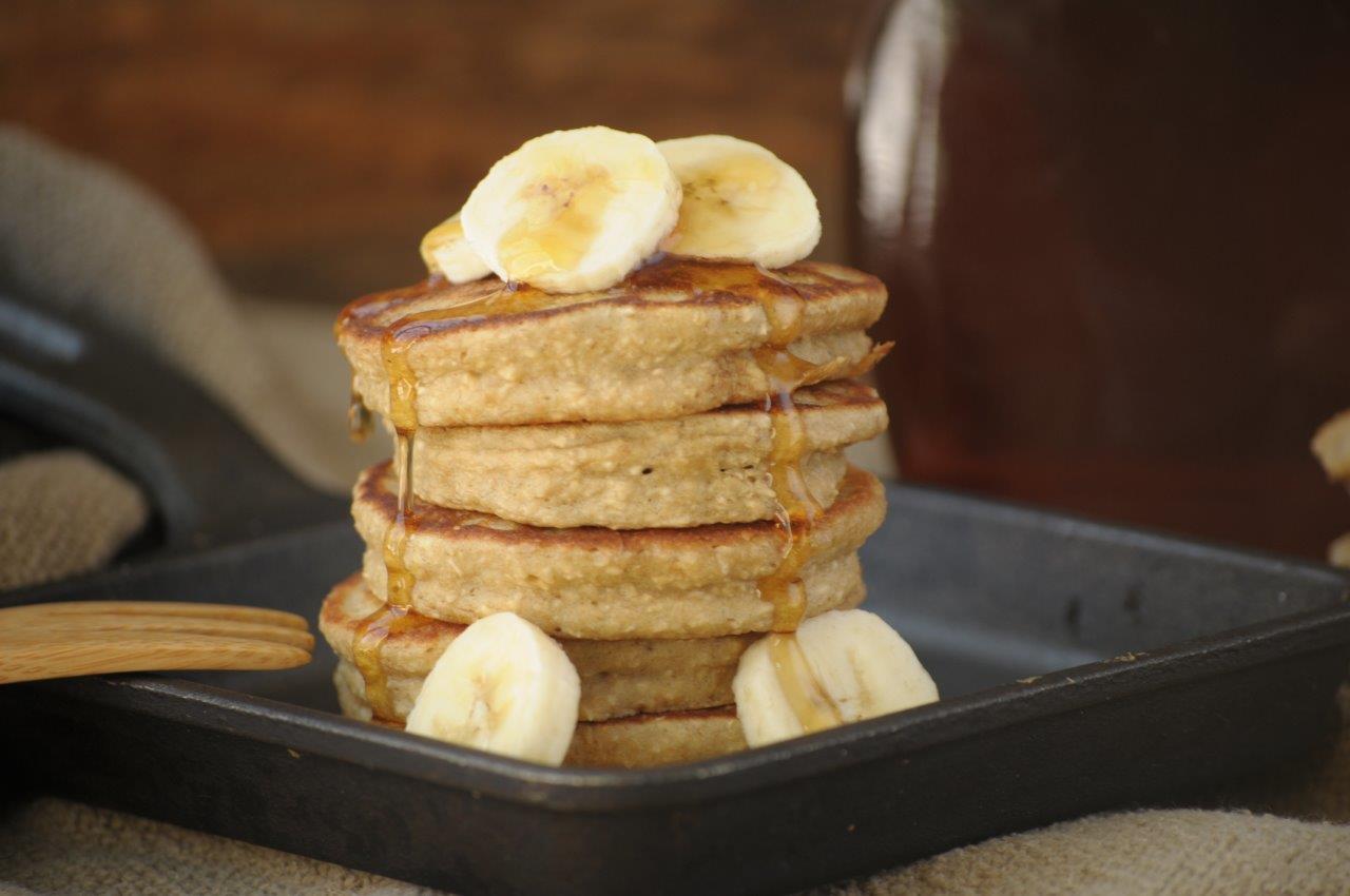 Nutritious Breakfast Ideas for Busy People. A stack of banana pancakes with bananas on top and maple syrup.