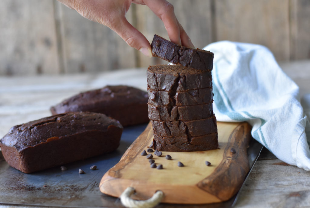 Grain Free Chocolate Banana Bread stacked with a person taking a slice.