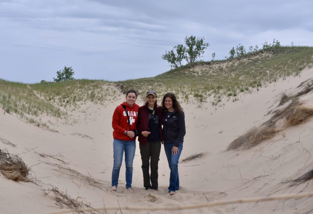 Explore Michigan Lighthouses & Sand Dunes. Three ladies standing on a sand dune.