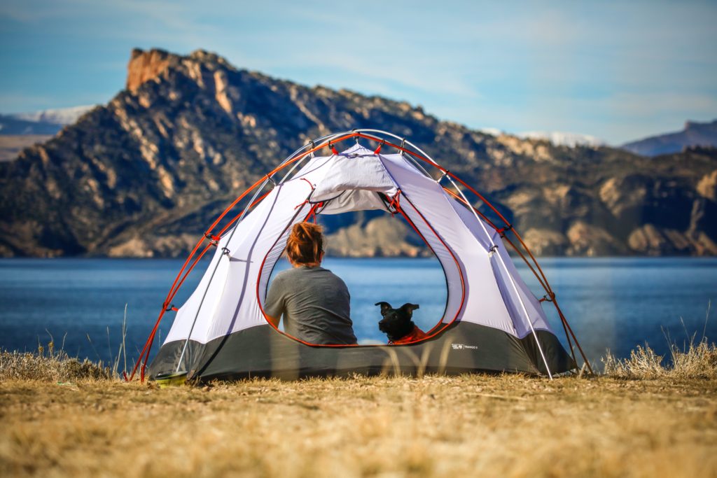 Healthy Meal Ideas for Camping Trips.  A women and her dog sitting in a tent.