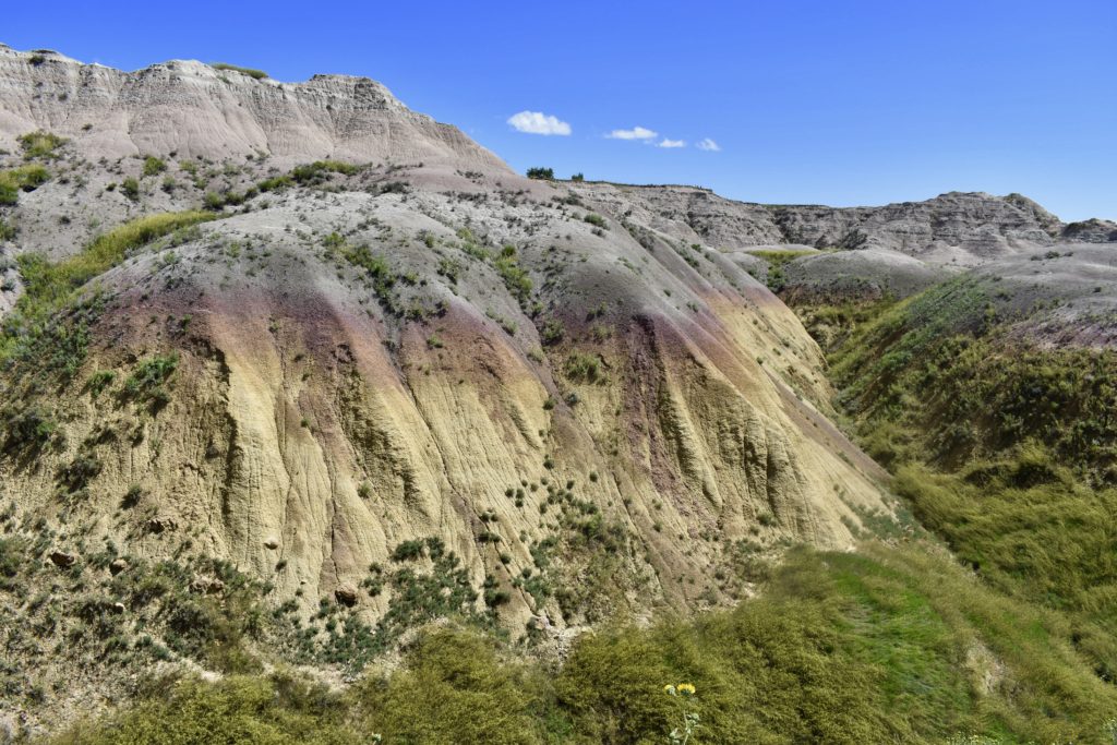 Visit Badlands National Park.  Yellow mounds at Dillion Pass along the Badlands Loop Drive.