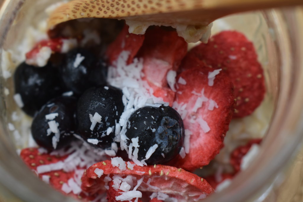 DIY Oatmeal Breakfast Cups.  Upclose picture of the berries and coconut flake toppings.