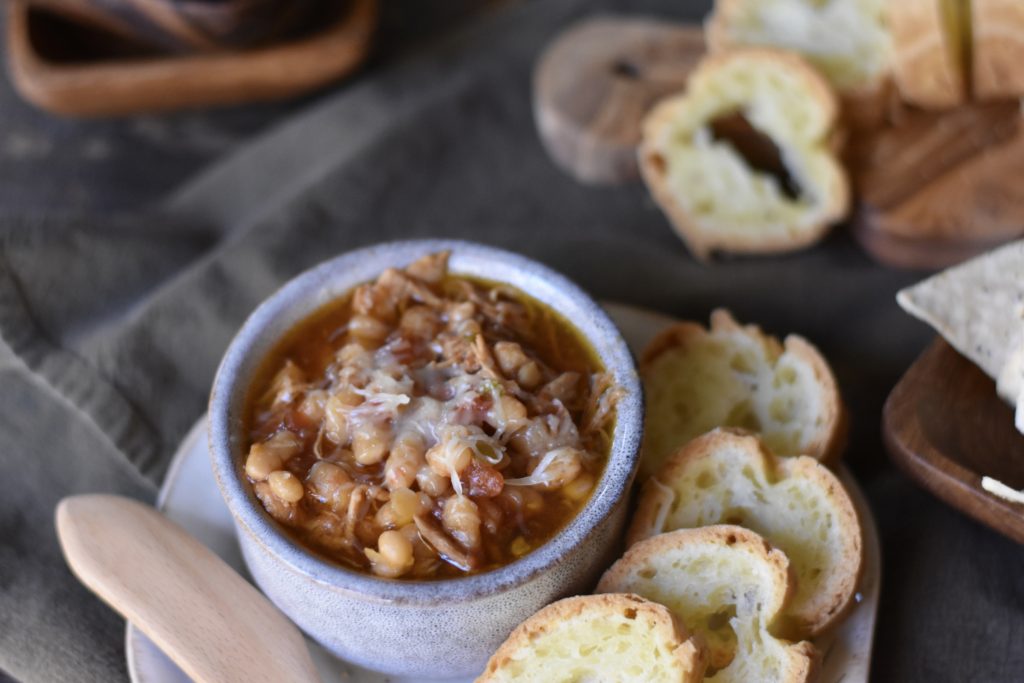 Gluten Free White Chicken Chili.  A bowl of chili next to sliced grain free baguette.
