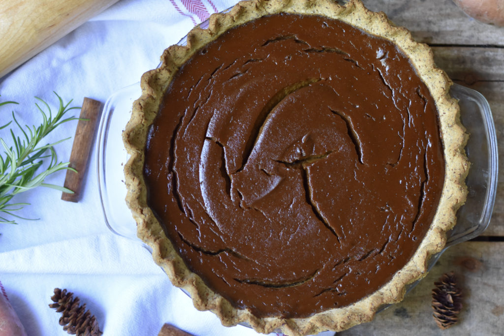 A whole sweet potato pie -Grain free & Dairy free on a wooden table.