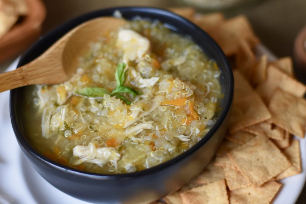 Chicken and Quinoa Soup in a bowl with crackers on the side.