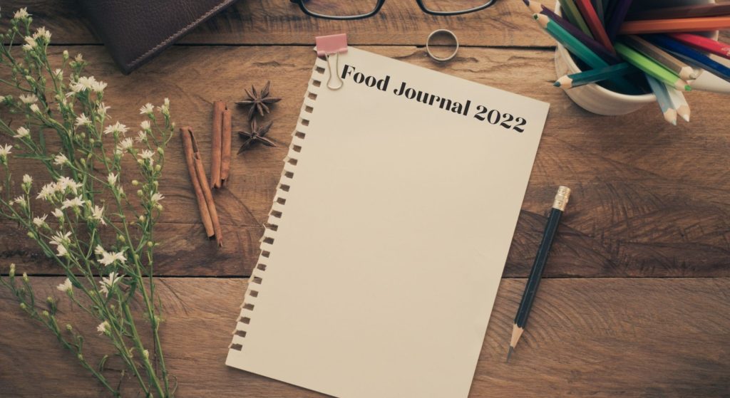 Food Journaling and Your Health with a blank journal and pencils.
