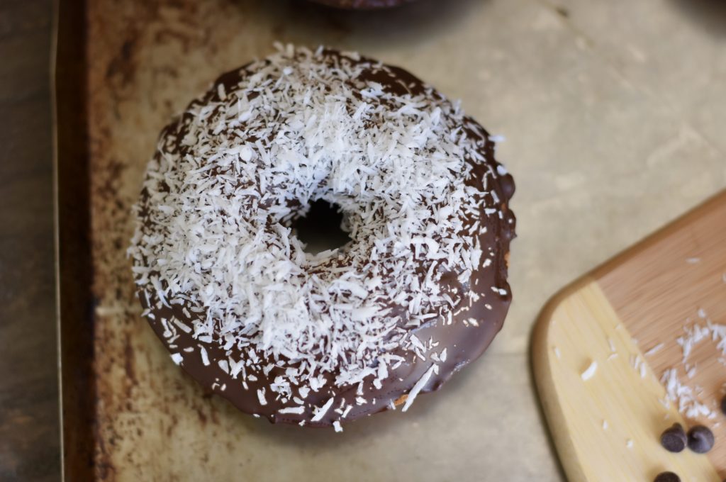 Grain Free Pumpkin Doughnut topped with chocolate and coconut flakes.