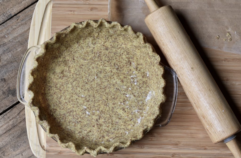  A pie crust with a rolling pie by it waiting to be made into Sweet Potato Pie - grain free and dairy free.