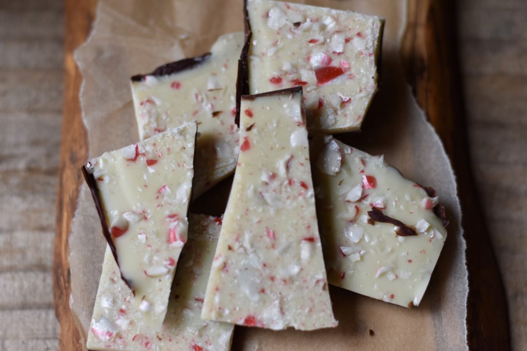 Gluten free white chocolate peppermint bark served on a wooden board.