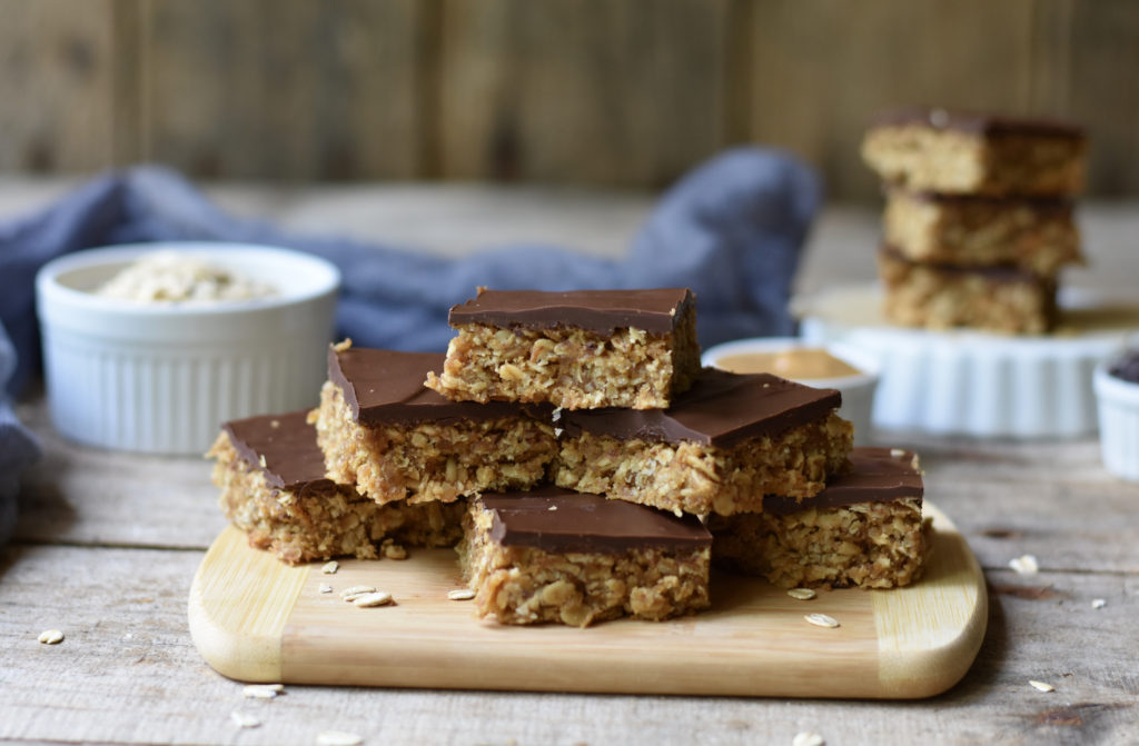 Gluten Free Oatmeal peanut butter chewy bars stacked on a board.