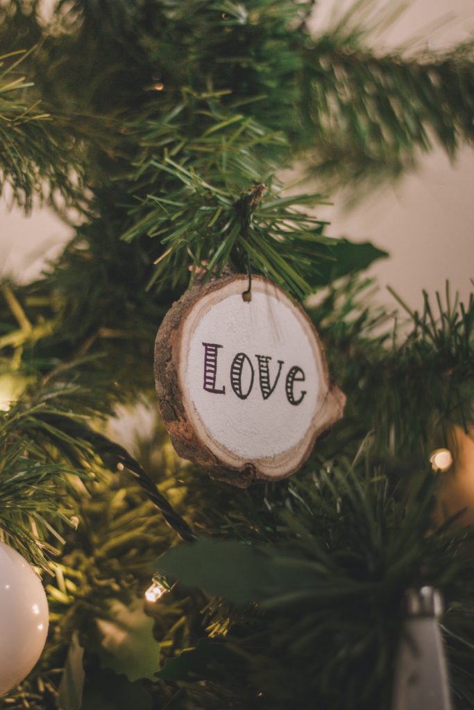 Natural Living Stocking Stuffer Gift ideas with a small ornament that says Love on it having on a tree.