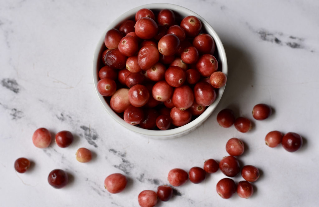 A bowl full of cranberries that are used in grain free cranberry orange strudel bars.