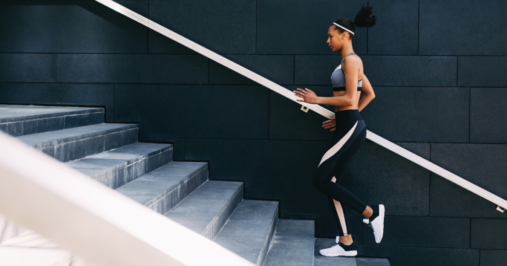  A women wearing athletic clothing going up stairs.