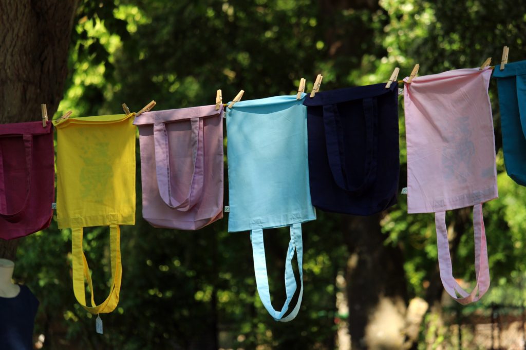 Yellow, purple, blue and black cloth bags on a line.