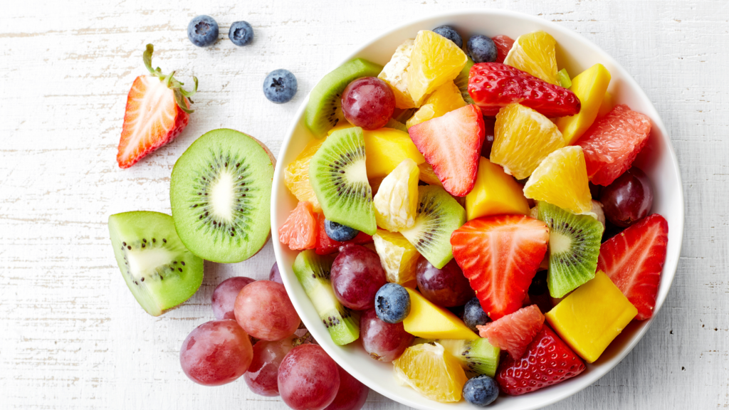 Choose your fruit wisely with a white bowl full of cut fruit that includes strawberries, pineapple, grapes and kiwi.