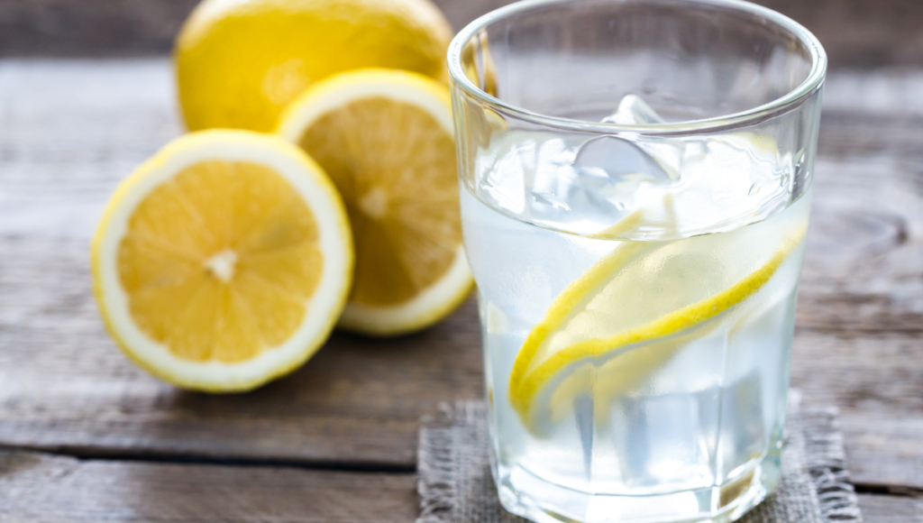 Homemade hydration electrolyte drink with a glass of water and sliced lemons.