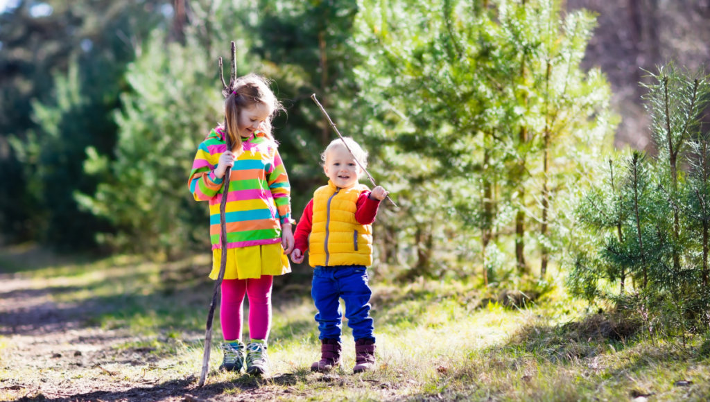 Tips for Cultivating health conscious kids.  A boy and girl on a trail holding walking sticks.