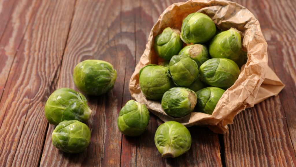 Brussel sprouts coming out of brown paper bag. They make a great addition to roasted vegetables and mushrooms side dish.