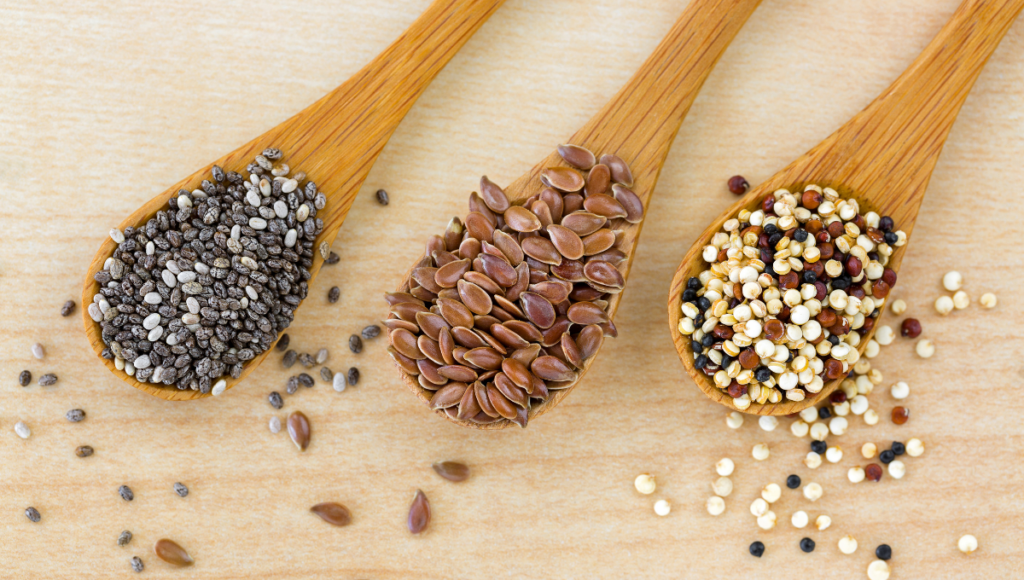 Benefits of soaking seeds and grains with three wooden spoons each holding a different seed.