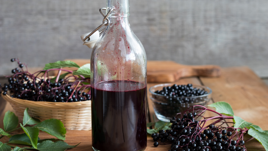 Benefits of using elderberry syrup with a bottle of syrup on a counter.